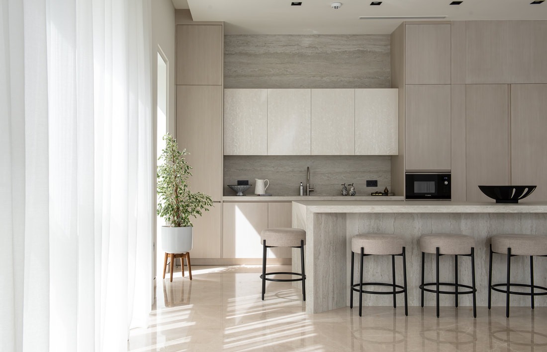 Golf Place villa kitchen designed and built by ACD Group, with a travertine island and pale oak cabinetry